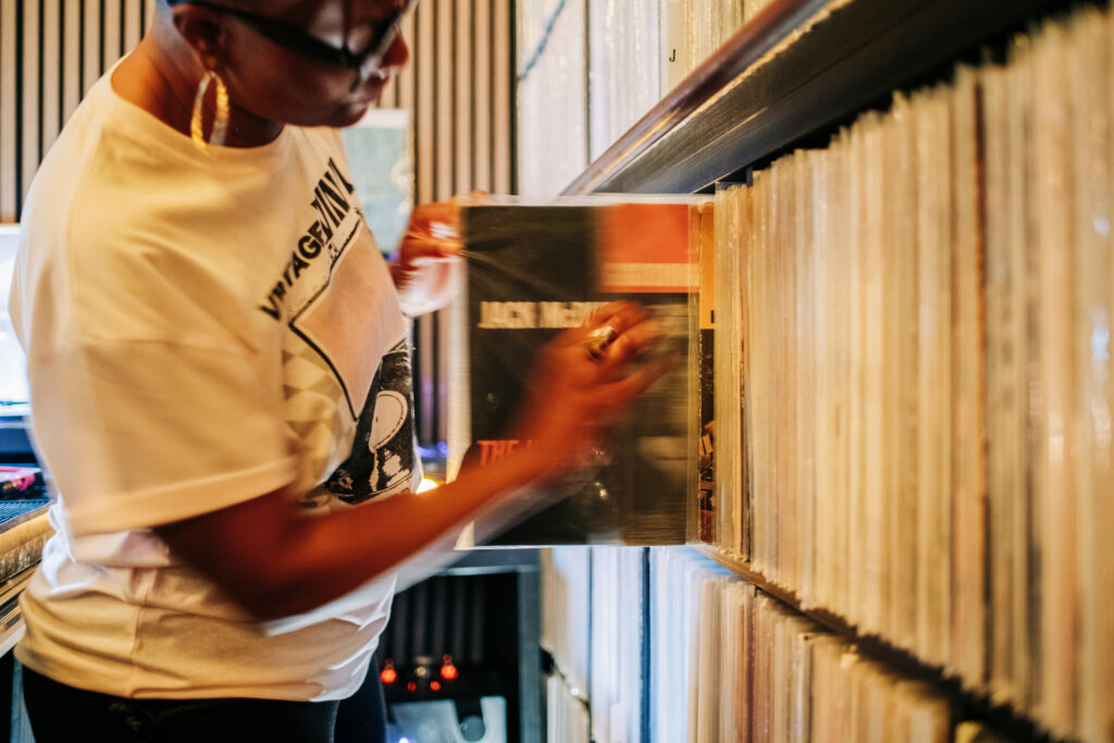 Guest selector pulls a record off the shelf from the house library of jazz vinyl at Kissa Kissa